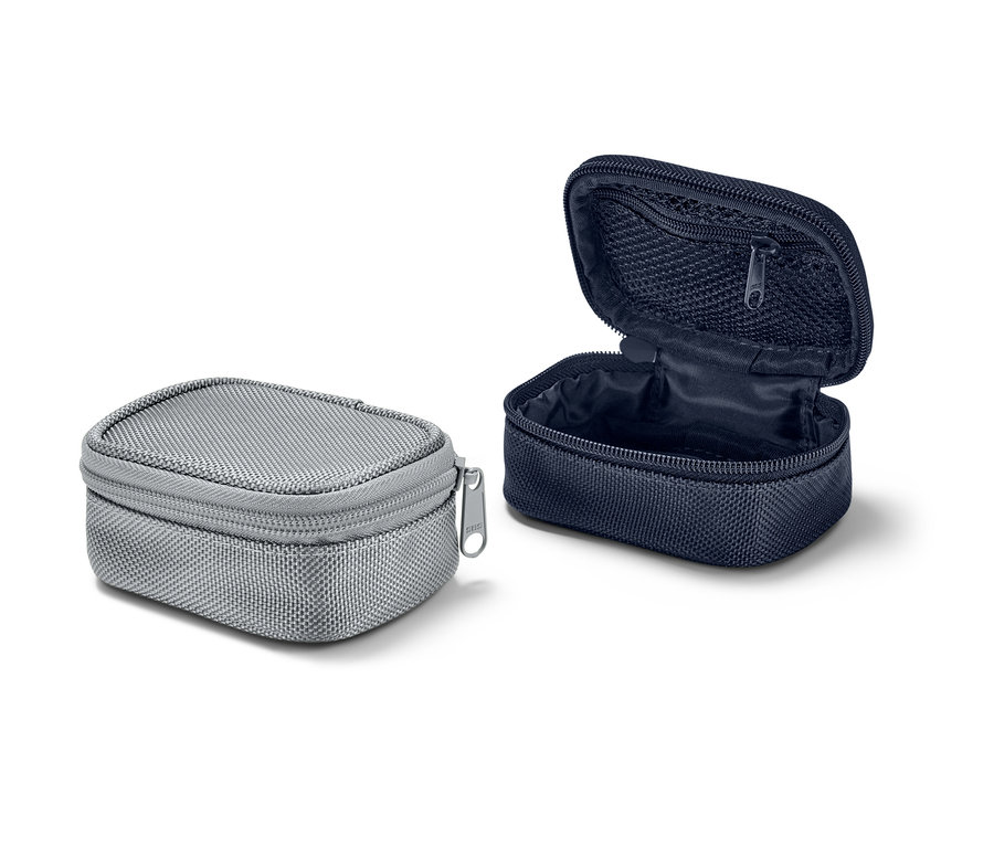 Dve malé cestovné taštičky: jedna sivá, zatvorená, a jedna tmavomodrá, otvorená.