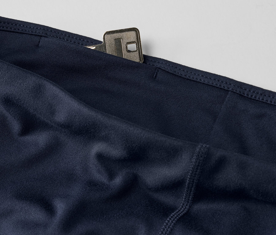 Detail tmavomodrých 3/4 športových legín s kľúčom vo vrecku.