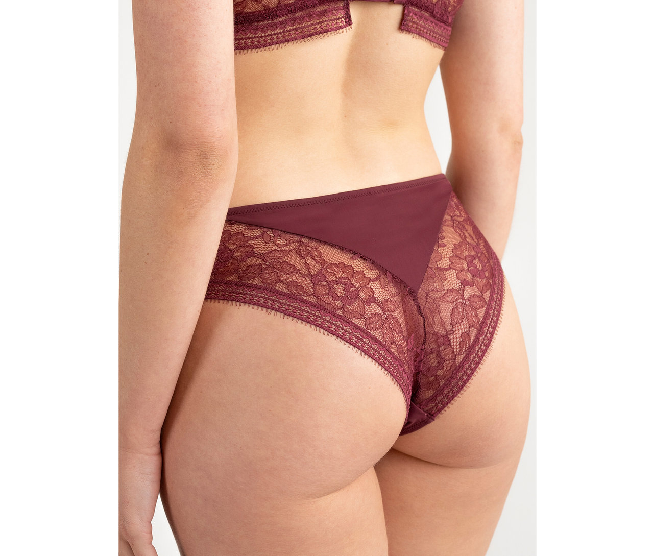 Pohľad zozadu na osobu v bordových nohavičkách Passionata Highwaist Slip »Jeanne« s čipkovanými detailmi.