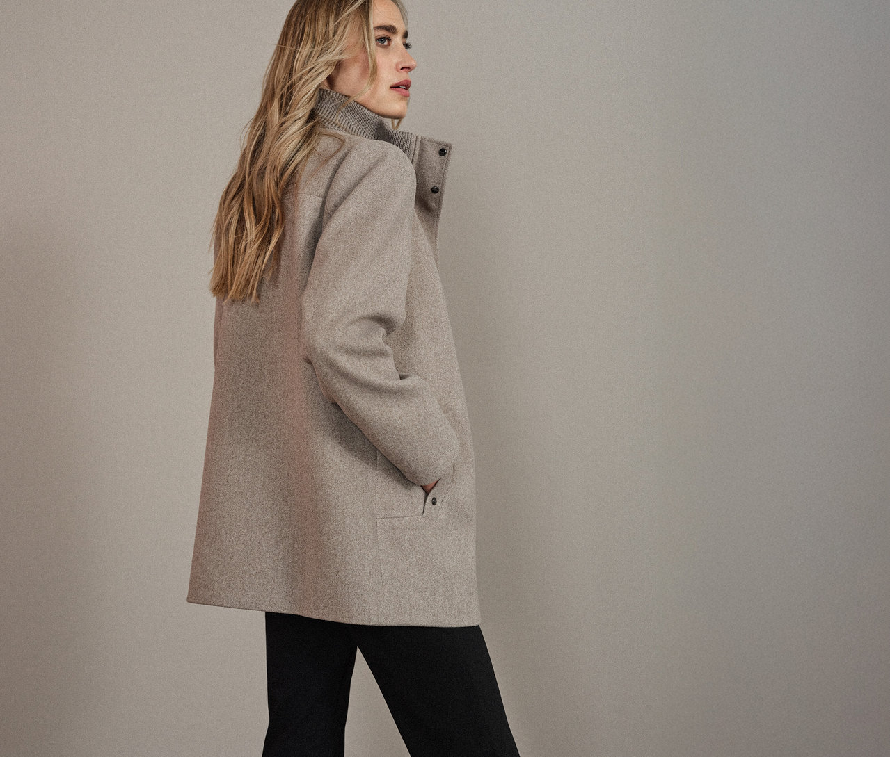 Žena v krátkom kabáte Street One, pozerá sa doľava.