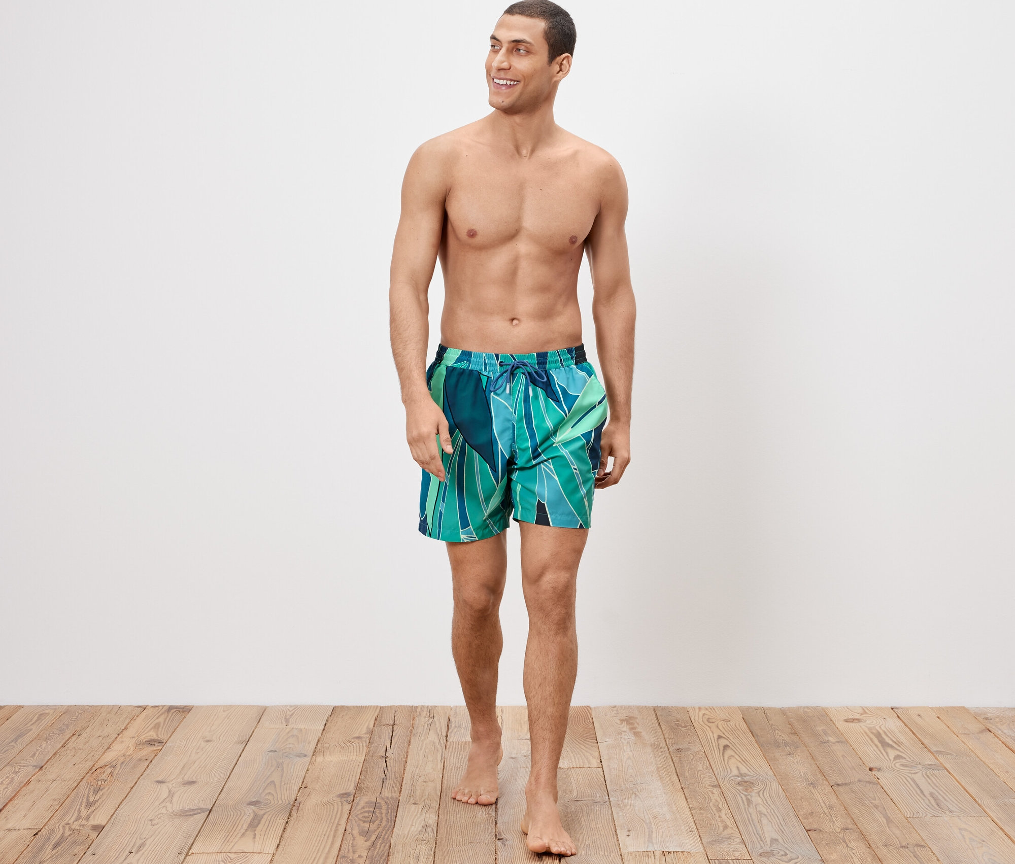 Muž kráča a má na sebe šortky na kúpanie.