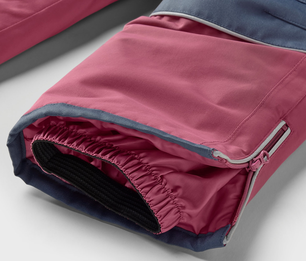 Detail nohavice z 2-dielnej detskej zimnej kombinézy ružovo-modrej farby.