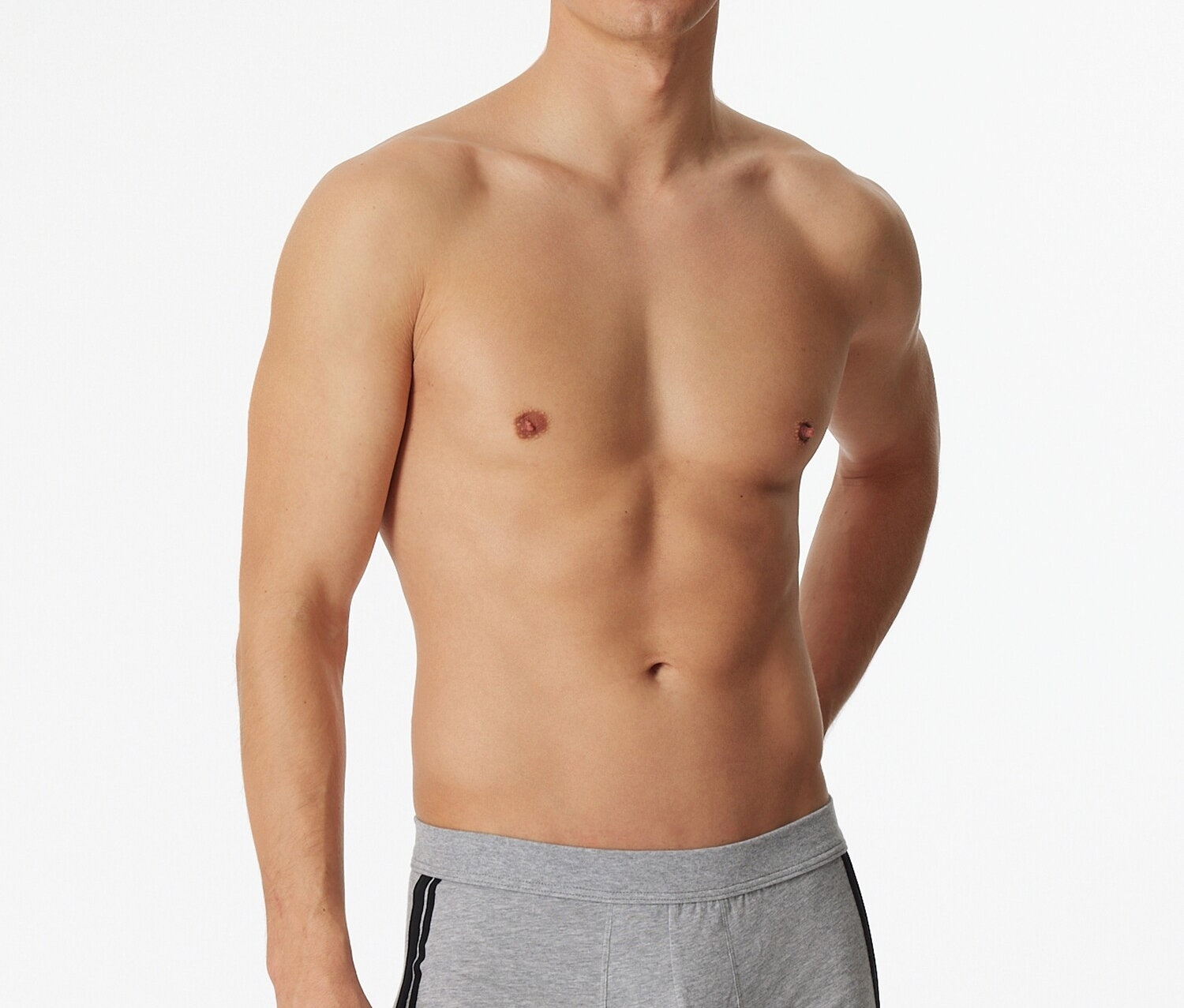 Muž pózuje bez trička v svetlosivých boxerkách SCHIESSER s melírom a čiernym pruhom na boku.