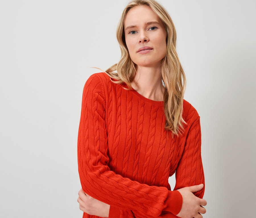 Blondína má na sebe oranžový sveter.