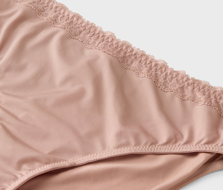 Detailný záber na svetloružové nohavičky s čipkou.