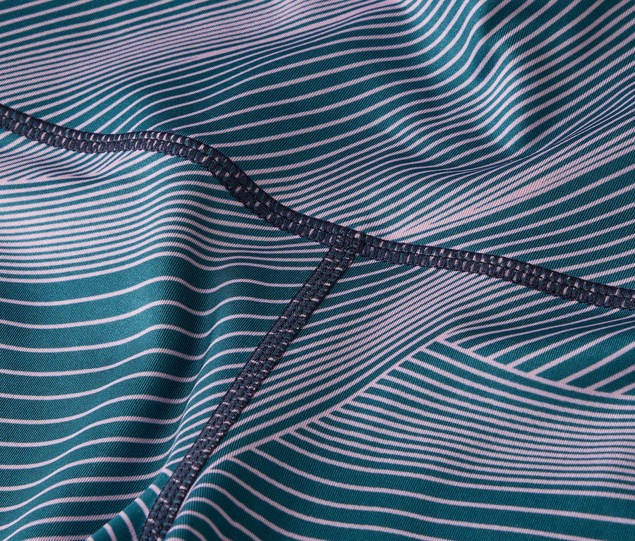 Detail látky legín s tyrkysovými a bielymi pruhmi a tmavým prešívaním.