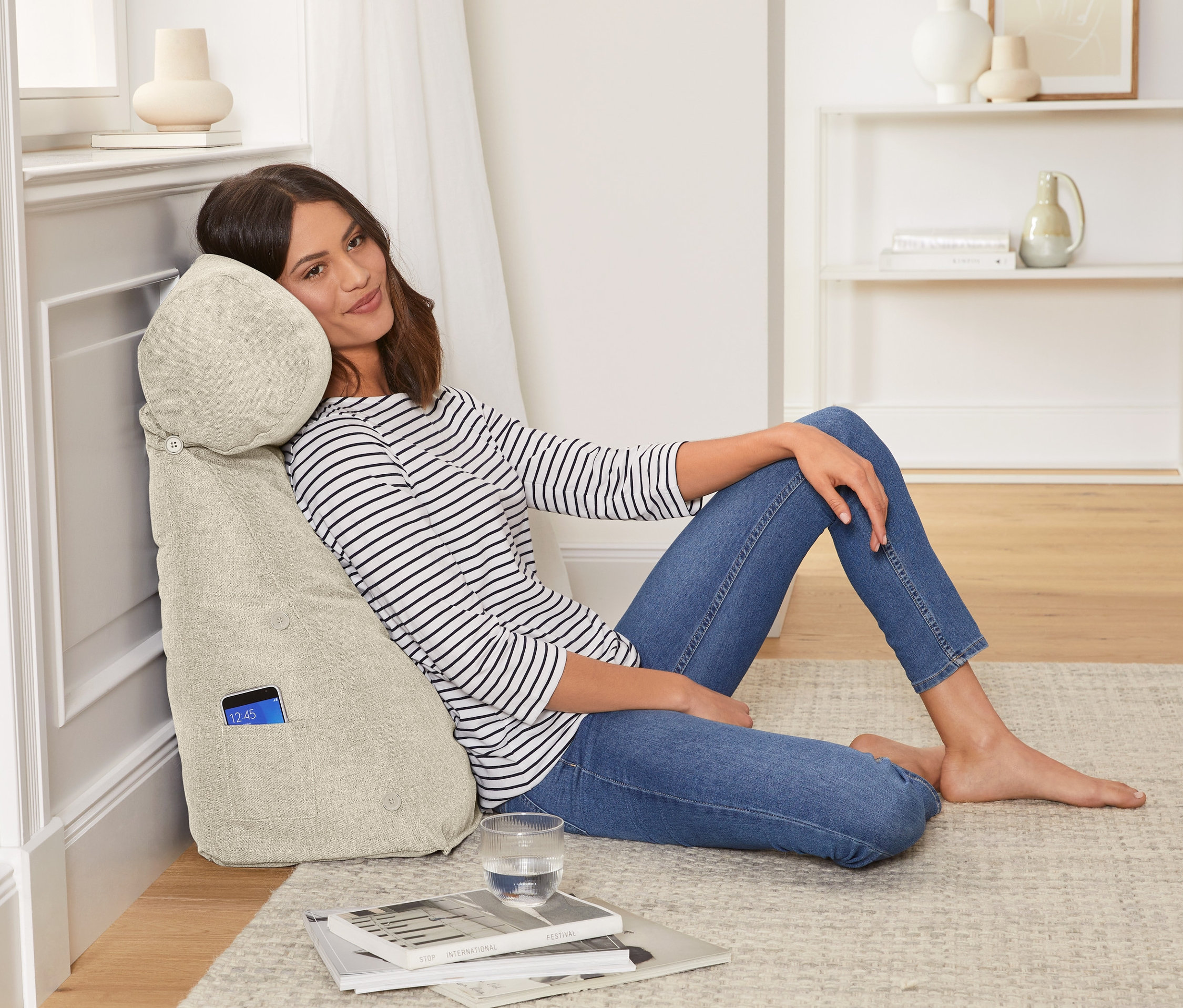 Žena sedí opretá o klinový vankúš.