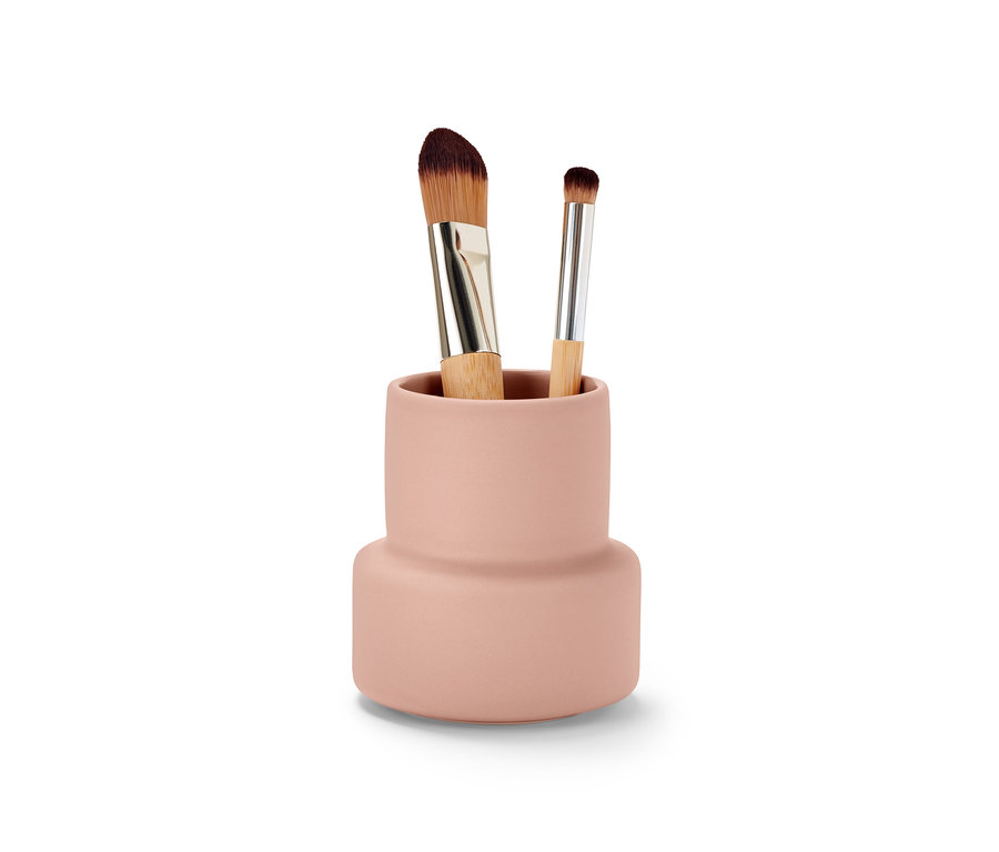 Dva štetce na make-up v ružovej nádobe na drobnosti.