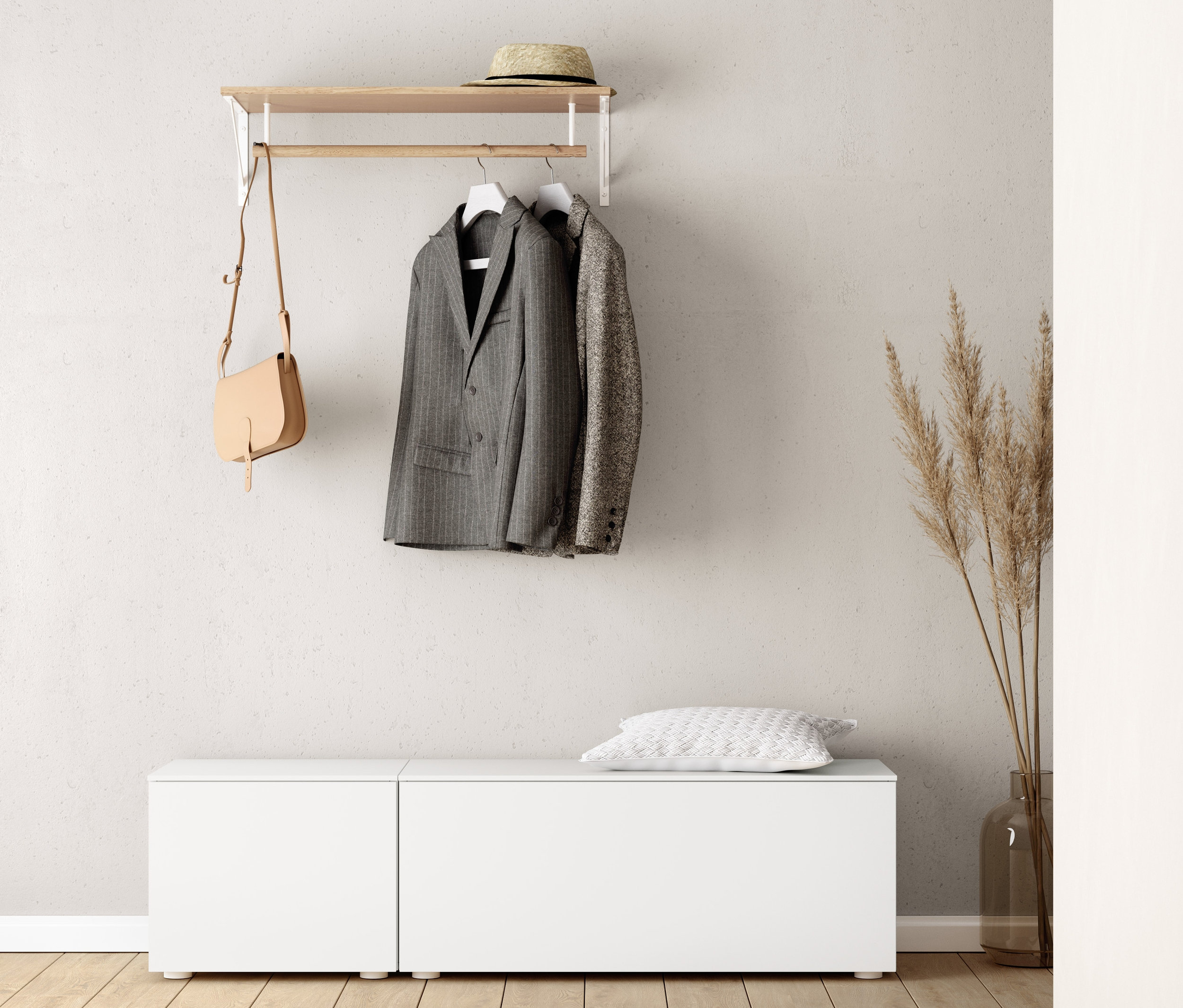 Na stene je nástenný vešiak, pod ním lavica (cca 50 cm) a lavica (cca 100 cm). Na vešiaku visí sako a kabelka. Na lavici leží vankúš.