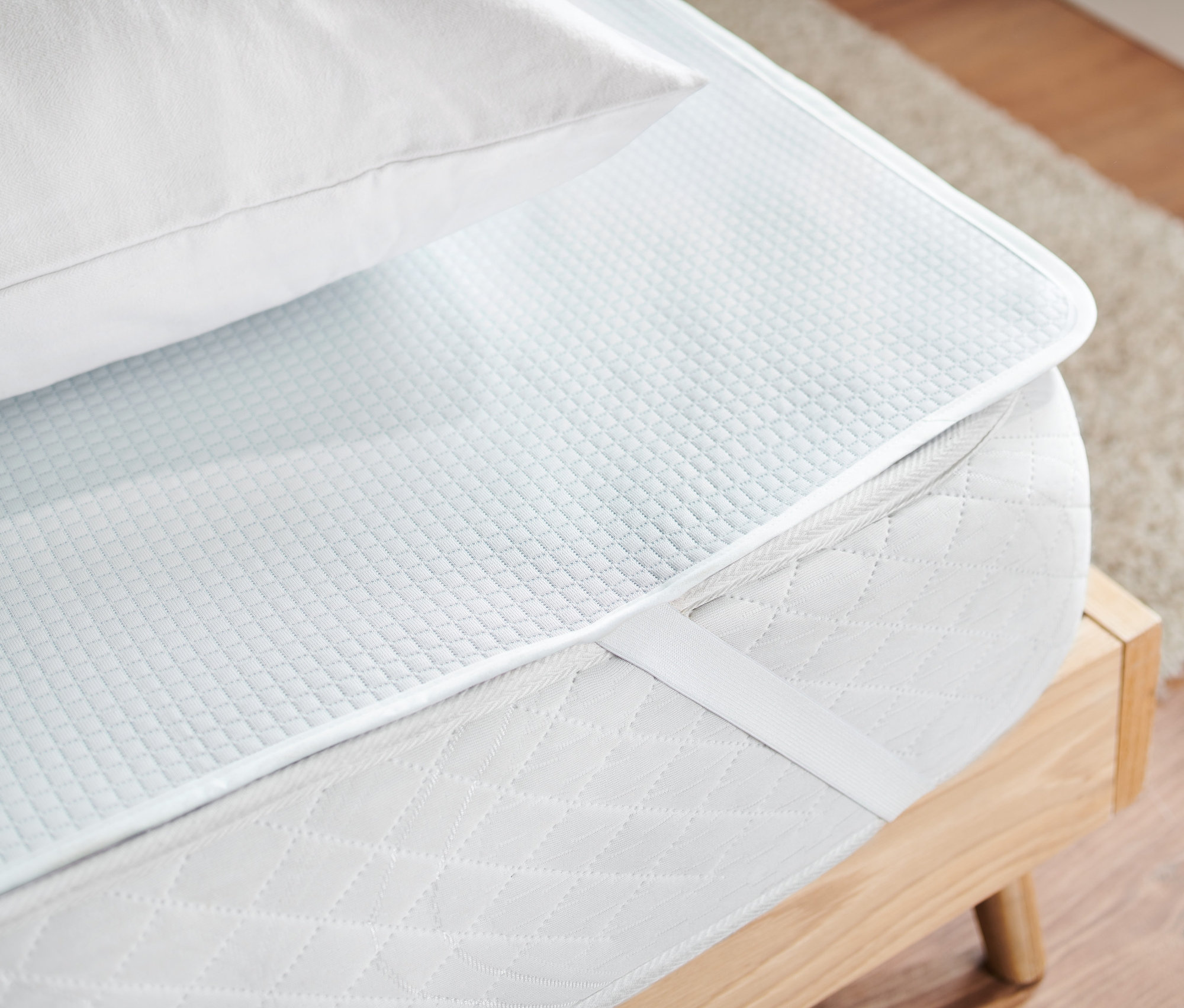 Na matraci leží napínací poťah na matrac a biely vankúš.