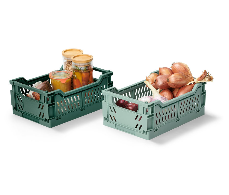 Dve sklápace úložné debničky, jedna zelená s naloženými pohármi, druhá svetlozelená s cibuľou a cesnakom.