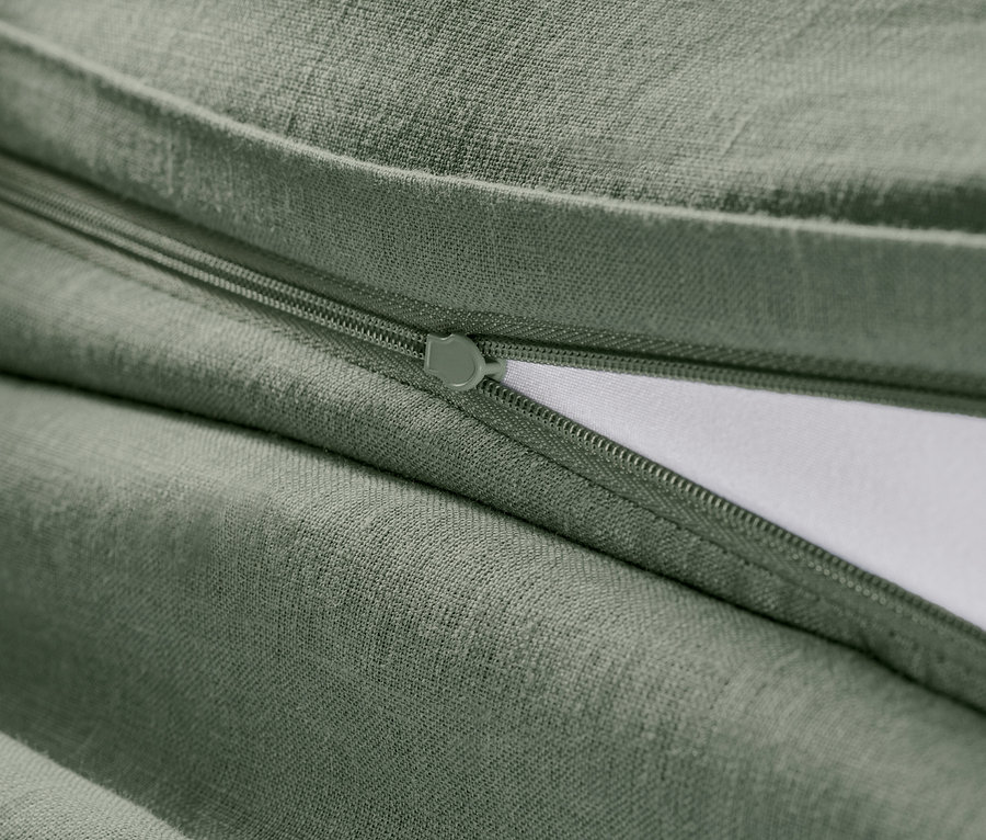 Detail zelenej ľanovej posteľnej bielizne štandardnej veľkosti so zipsom.