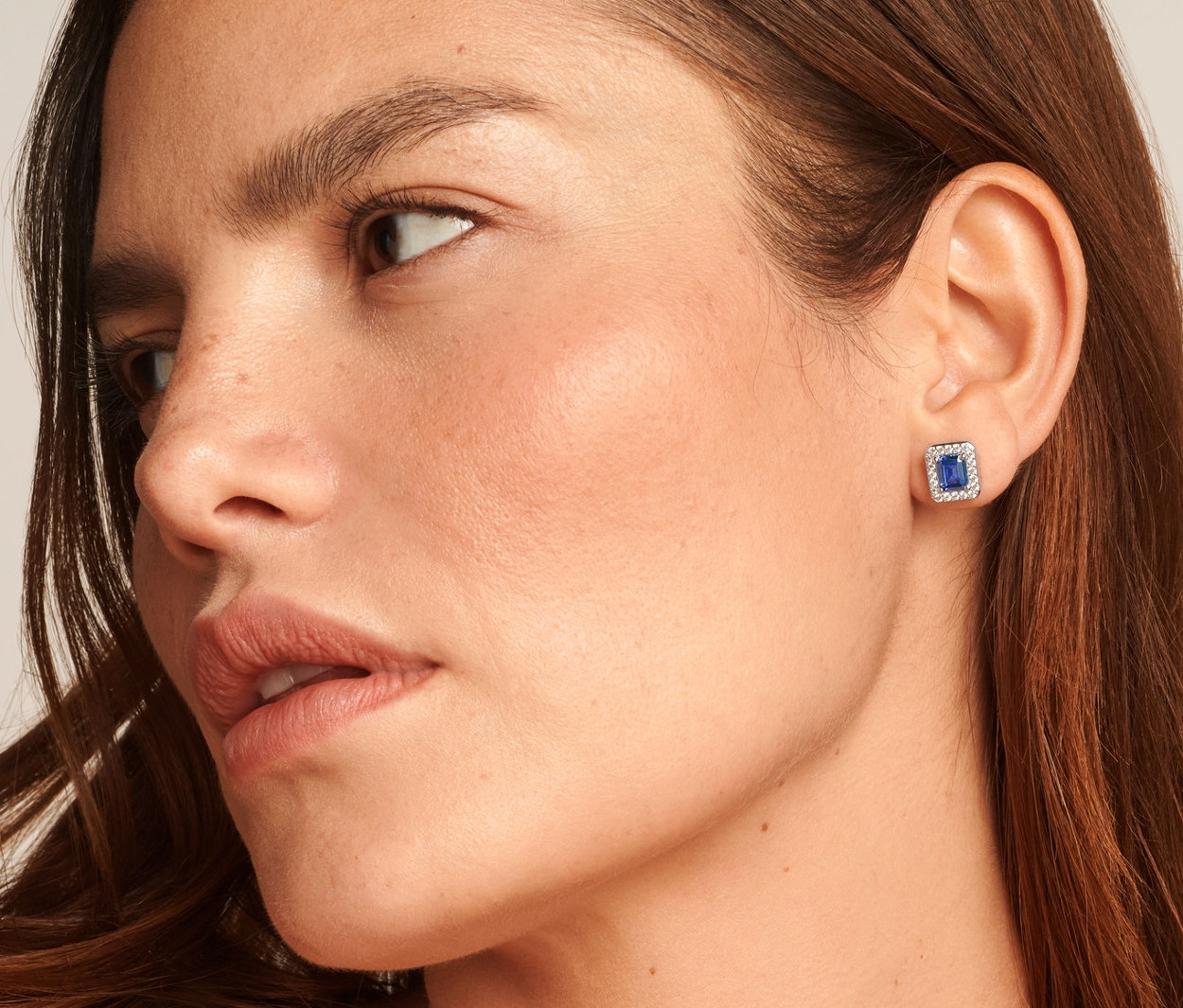 Detail ženy so striebornou retiazkou Royal Blue, rýdzosť 925, prsteňom Royal Blue, rýdzosť 925 a striebornými napichovacími náušnicami Royal Blue, rýdzosť 925.