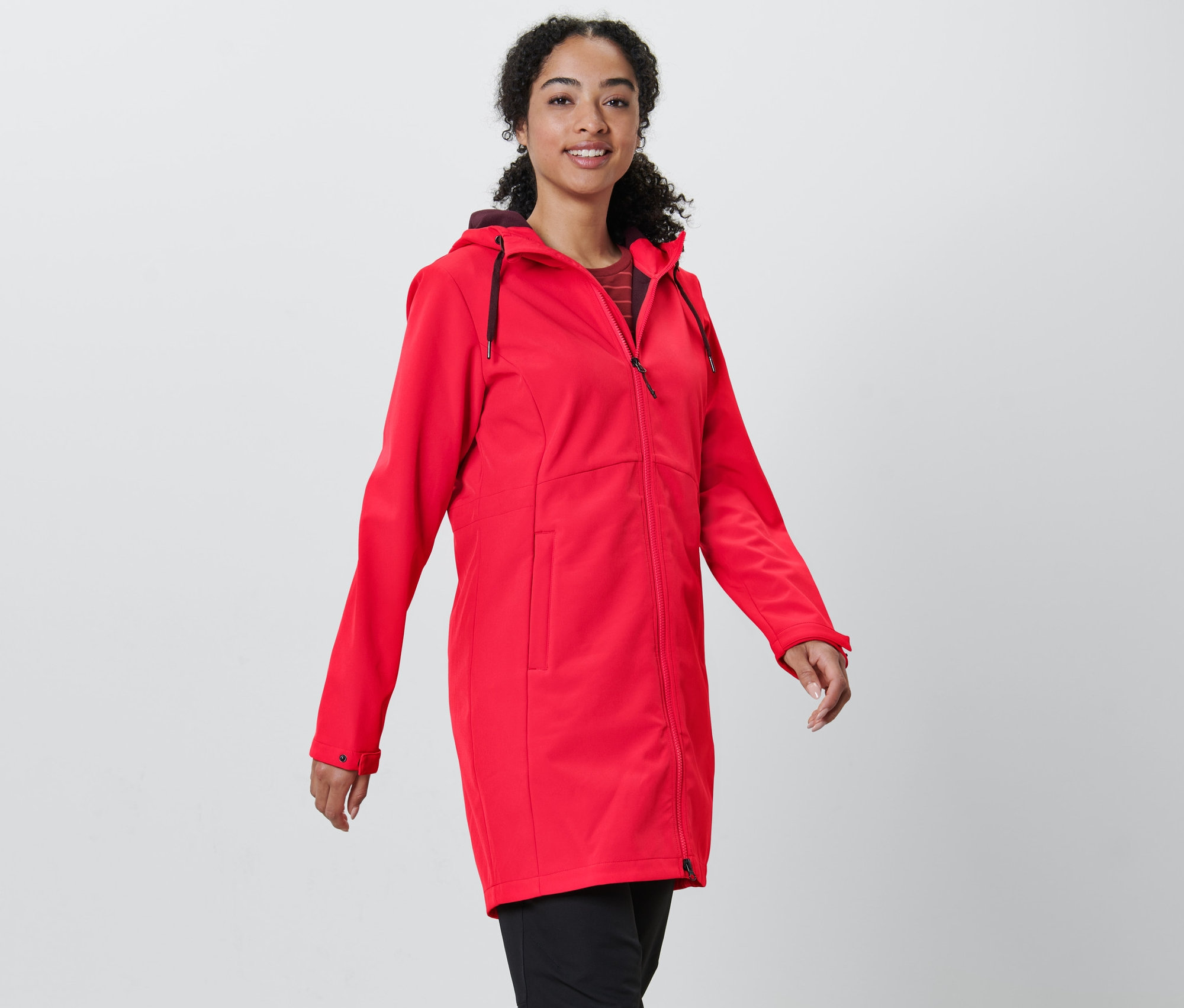 Žena má na sebe červený softshellový kabát.