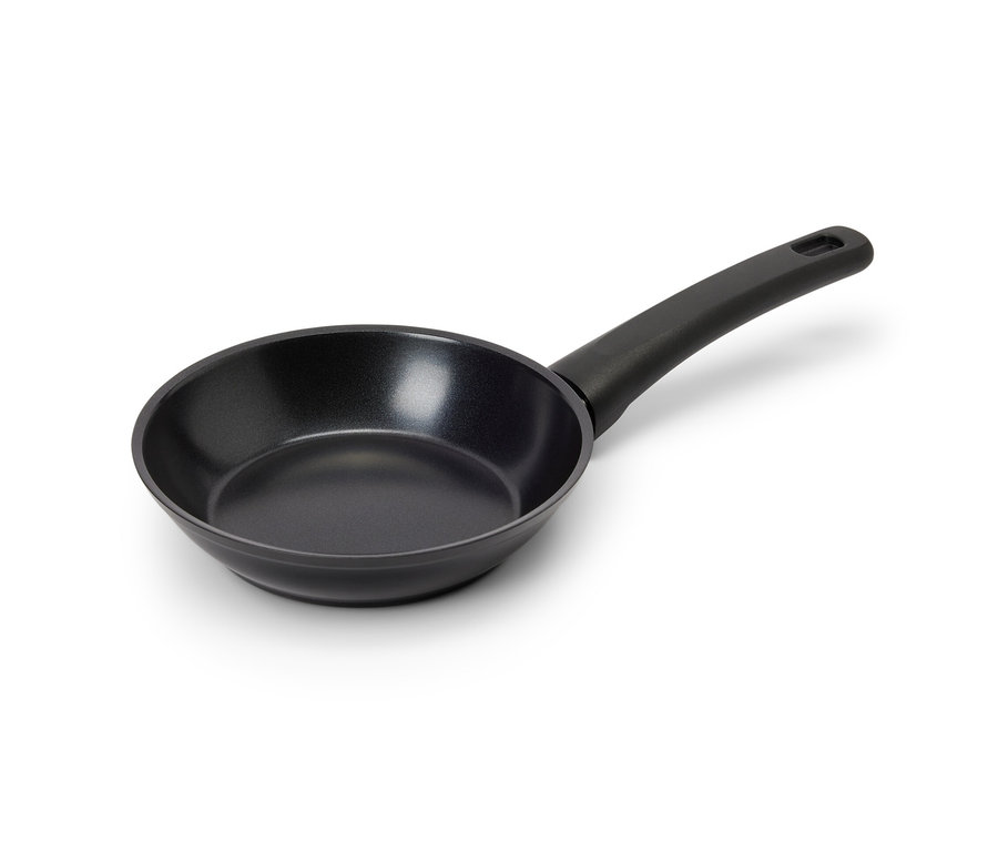 Čierna mini panvica s nepriľnavou povrchovou úpravou a rukoväťou leží na bielom povrchu.