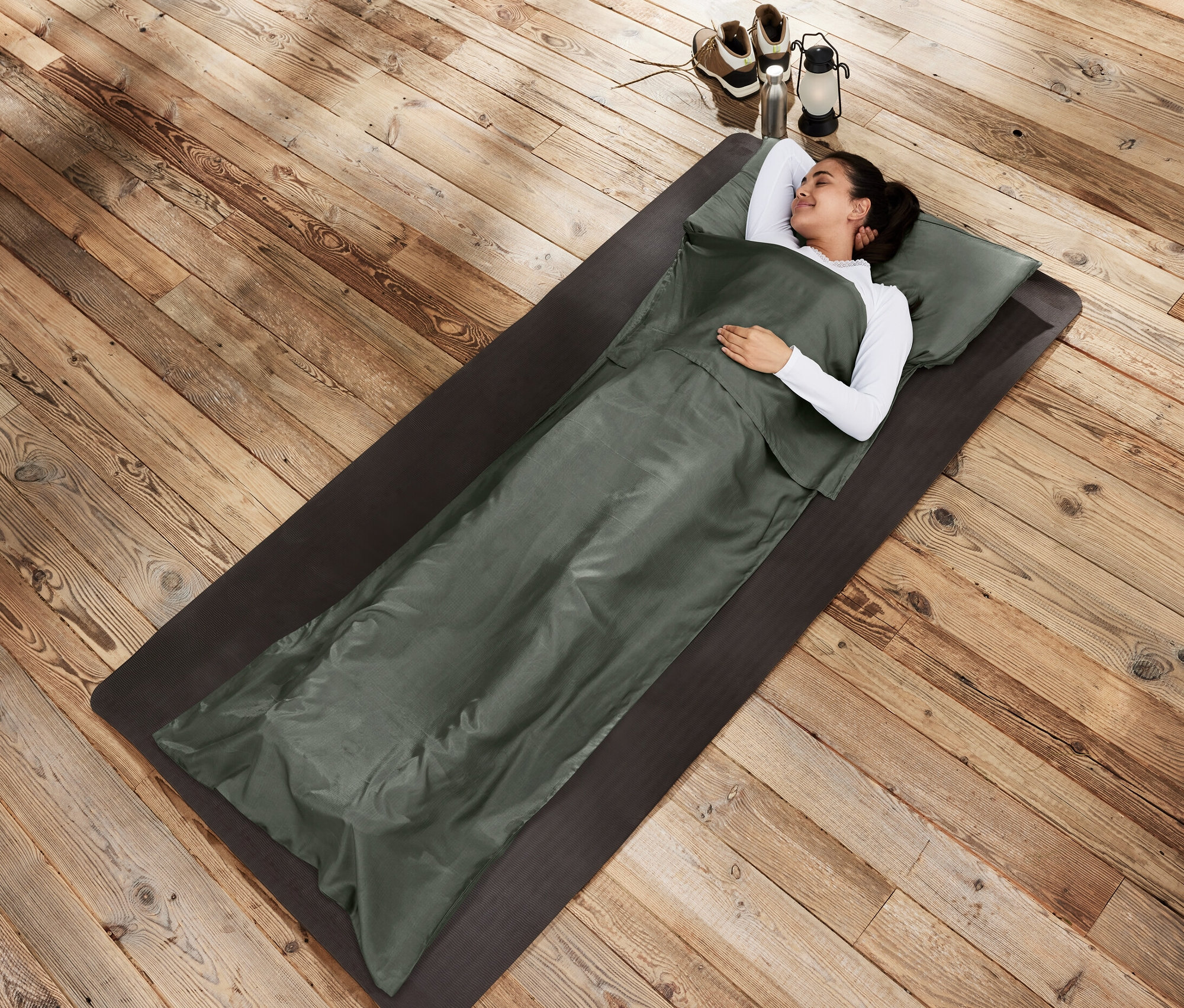 Žena leží na podložke v spacom vaku Hodvábna vložka do spacieho vaku.