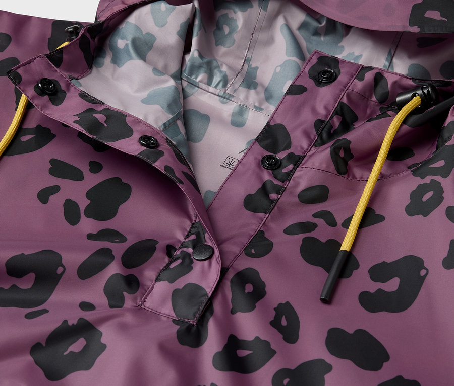 Detail fialovej bundy s kapucňou a čiernym zvieracím vzorom.
