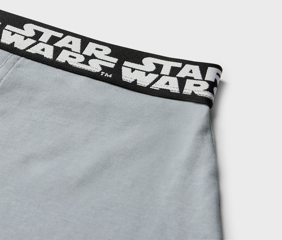 Detail sivých boxeriek s čiernym pásom s bielym nápisom STAR WARS.