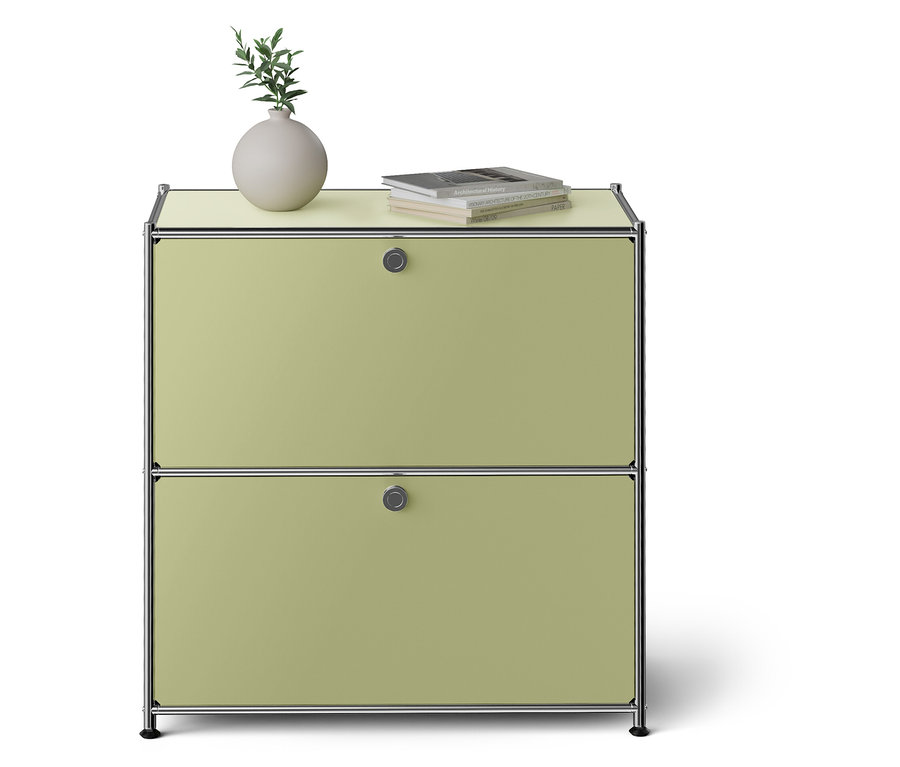 Zelená skrinka s dvomi zásuvkami. Na vrchu váza a kniha.