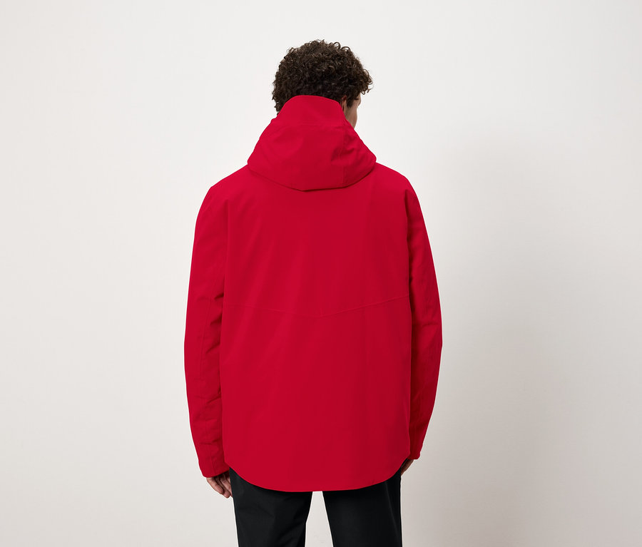 Muž chrbtom k fotoaparátu má na sebe červenú bundu s kapucňou.