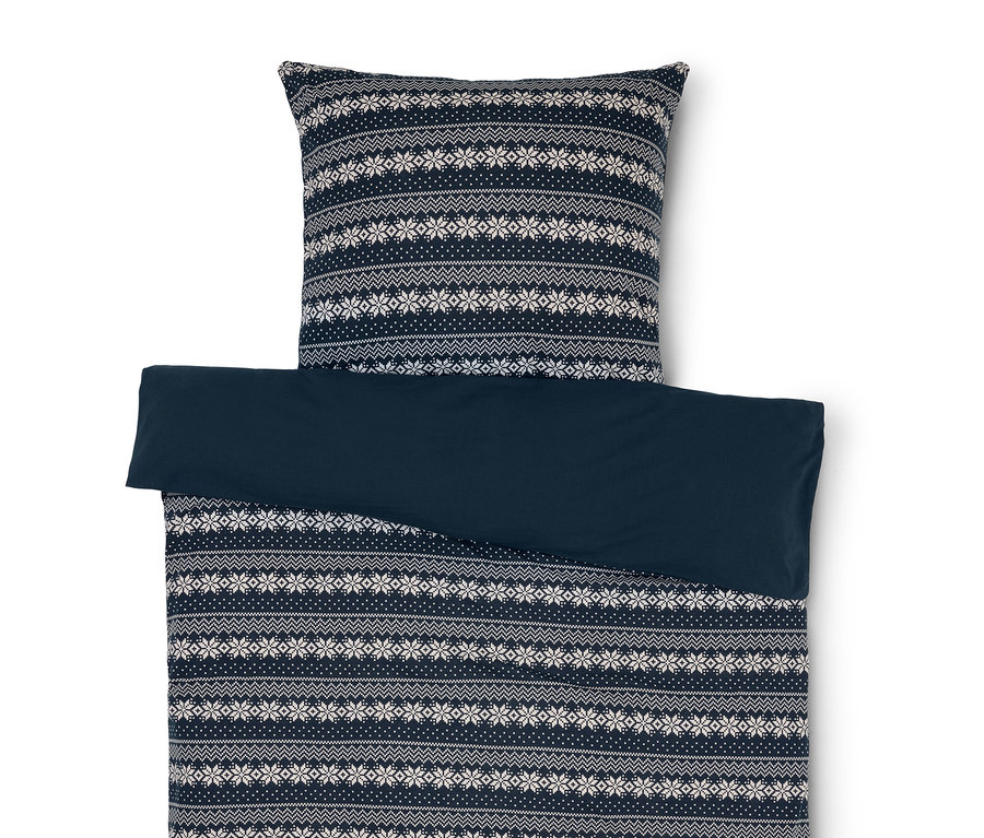 Posteľná bielizeň s modro-bielym vzorom snehových vločiek a jednofarebná modrá obliečka.