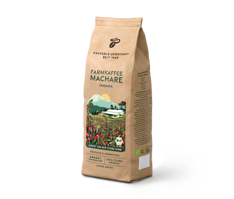 Stojace hnedé balenie kávy Farmkaffee Machare z Tanzánie, s ilustráciou kávovej plantáže, hory a domu. Obsahuje 500g celých zŕn.