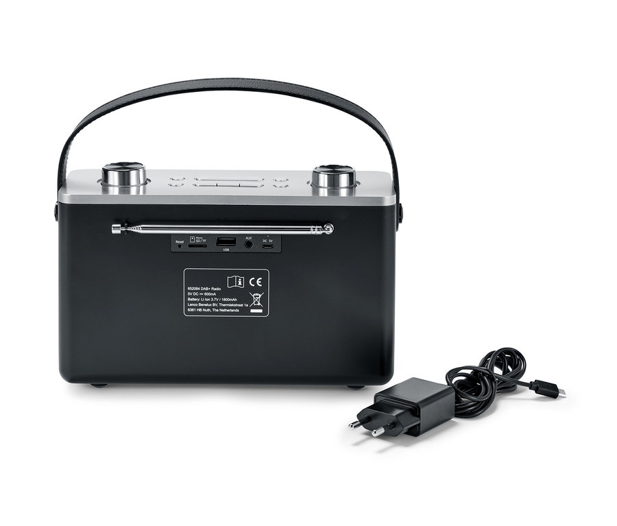 Čierne digitálne rádio DAB+/FM s Bluetooth® a napájací adaptér leží vedľa neho.