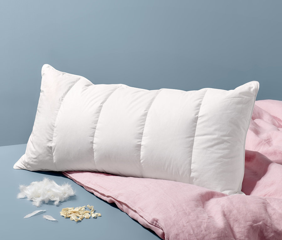 Biely prešívaný vankúš na spanie s výplňou s borovicou limbovou, cca 80 x 40 cm, leží na ružovej ľanovej plachte.