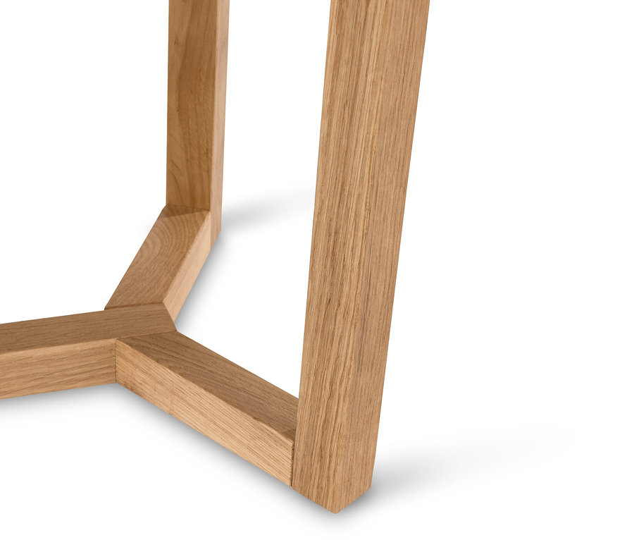 Detail nohy dreveného stolíka na bielom pozadí.