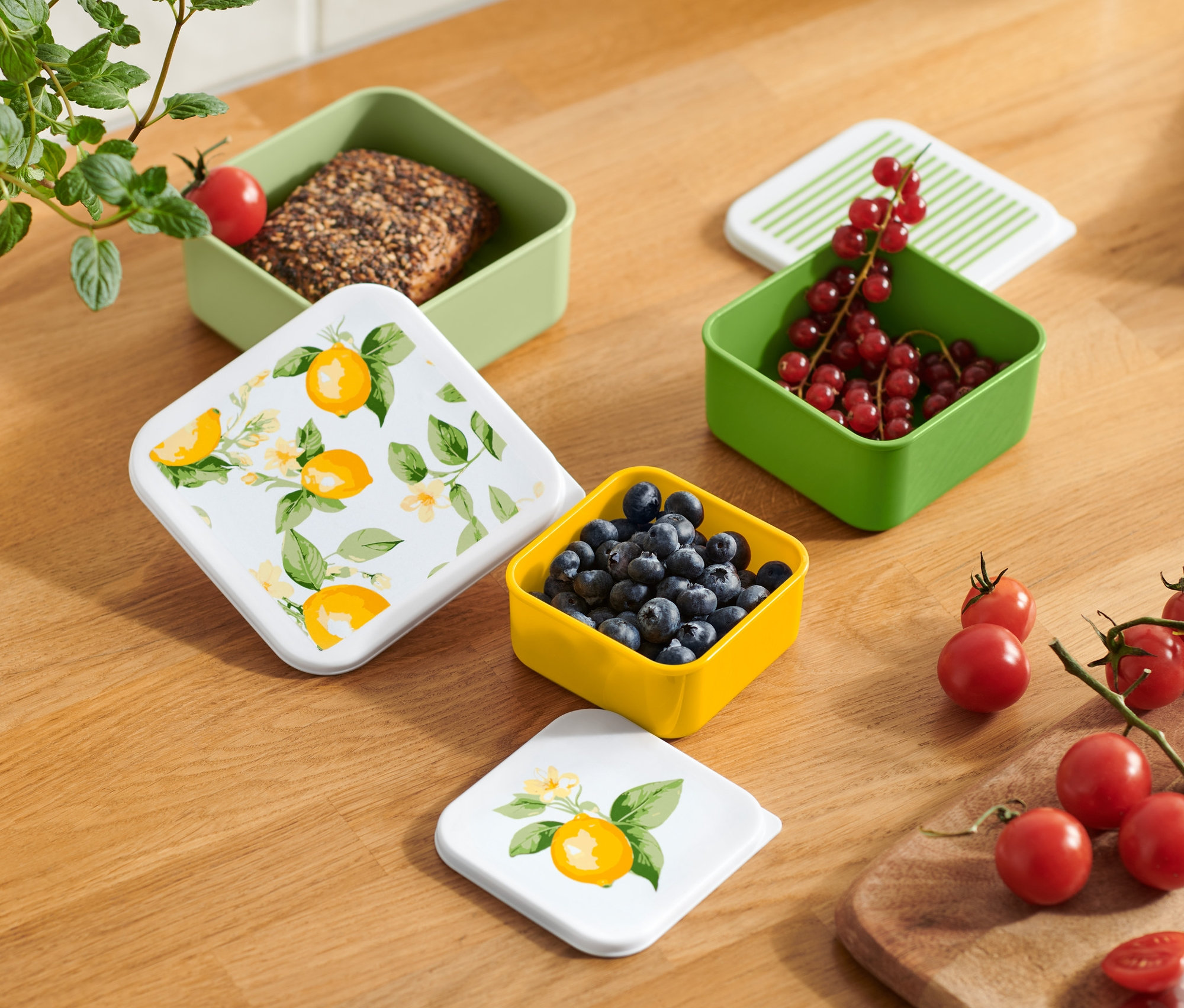 Pohľad zhora na drevený stôl s rôznymi farebnými desiatovými boxami s ovocím a zeleninou.