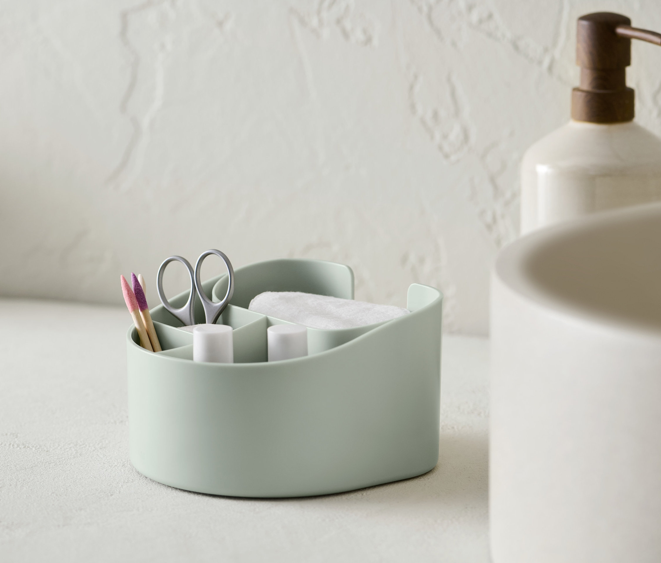 Svetlozelený kozmetický organizér s vatovými tampónmi, nožnicami a tyčinkami do uší.