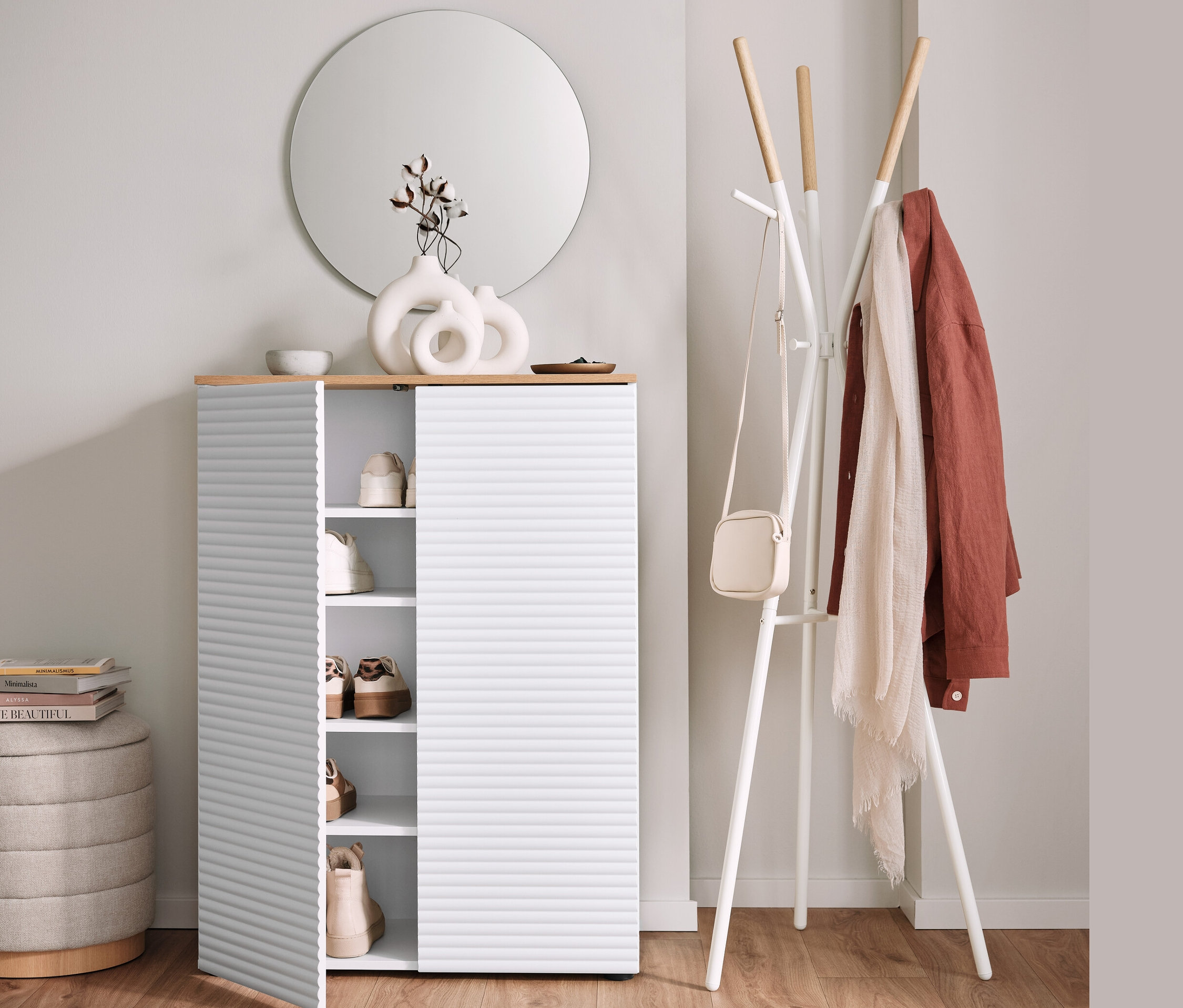 Skriňa na topánky s otvorenými dverami vedľa stojana na oblečenie a taburetky s úložným priestorom.