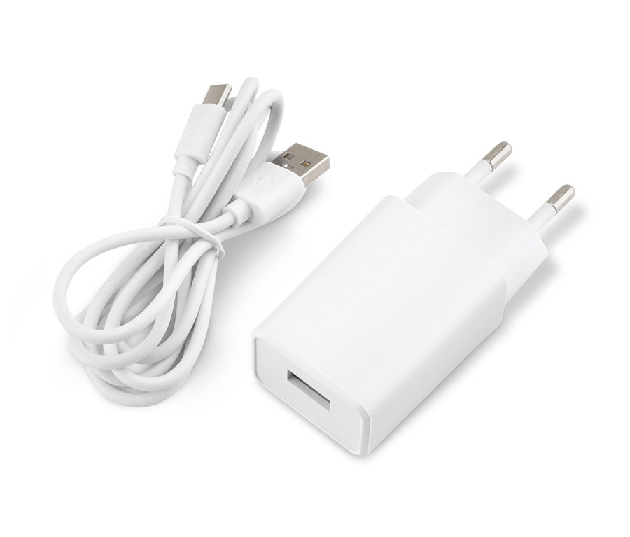 Biely adaptér a stočený USB kábel ležia na bielom povrchu.
