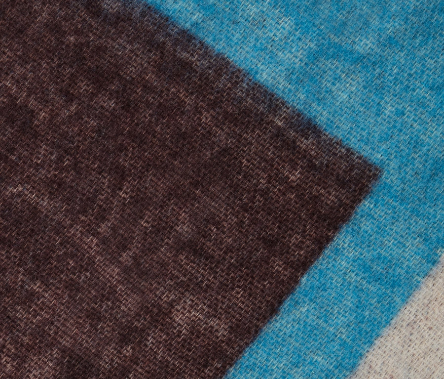 Detail tkaného šálu s modrými a hnedými pruhmi.