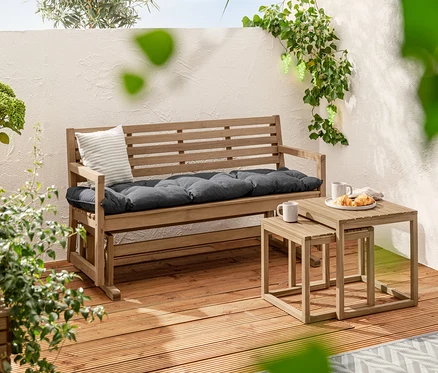 Dva odkladacie stolíky »Lenja« stoja vedľa záhradnej lavice s podložkou Sun Garden, cca 160 x 50 cm. V pozadí je solárna svetelná reťaz »Weintrauben« a 2 prémiové solárne nástrčné svietidlá.