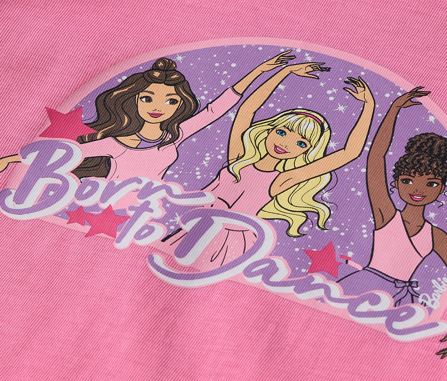 Na ružovom pozadí je ilustrácia troch postavičiek Barbie v baletných pozíciách s nápisom "Born to Dance".