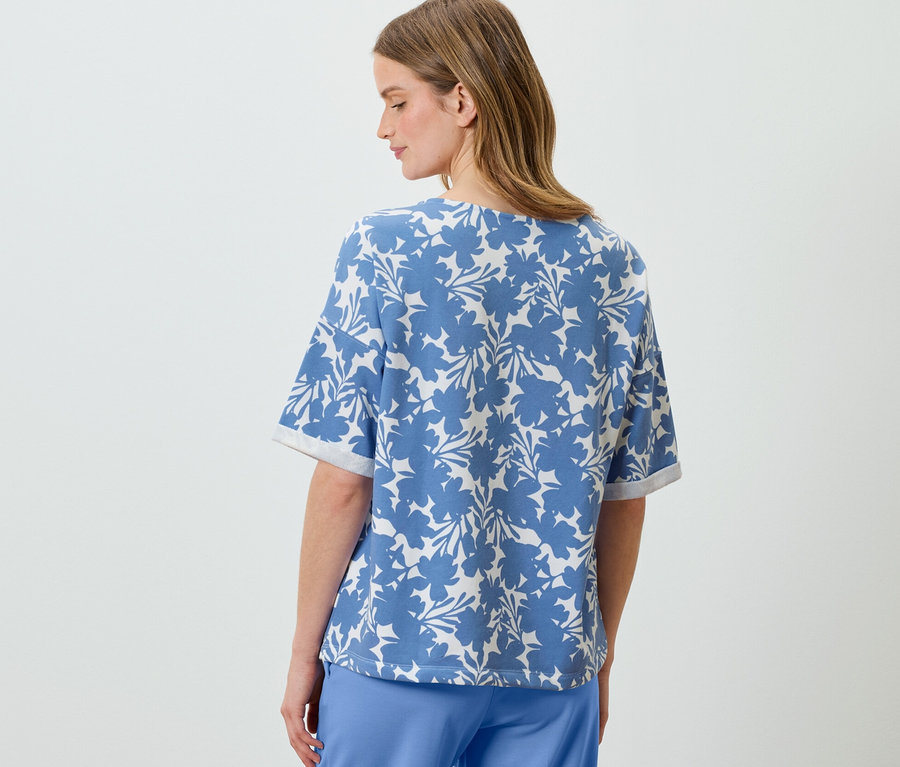 Žena má na sebe svetlomodrú mikinu s potlačou.