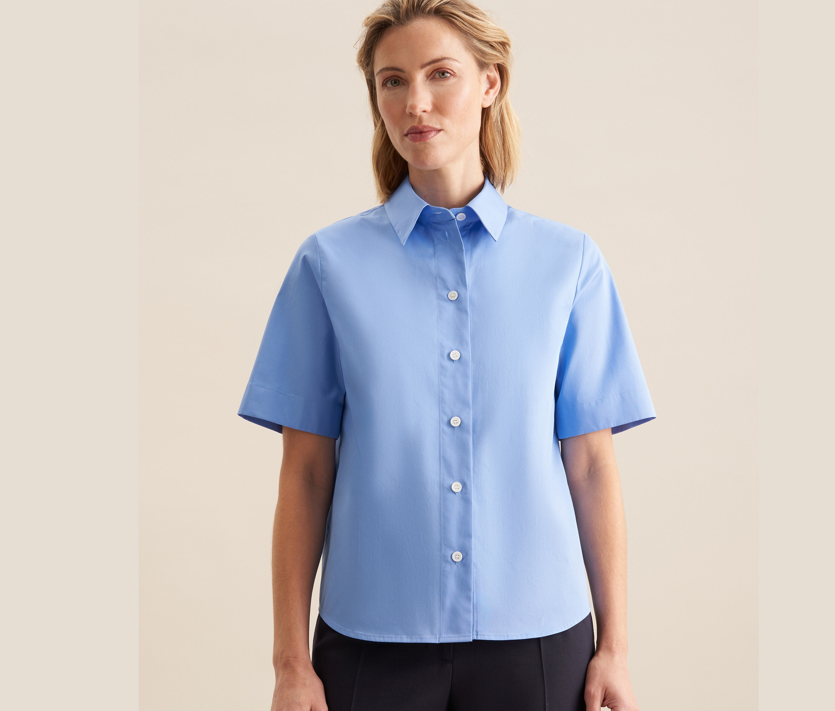 Žena má na sebe svetlomodrú blúzku s krátkym rukávom Seidensticker.