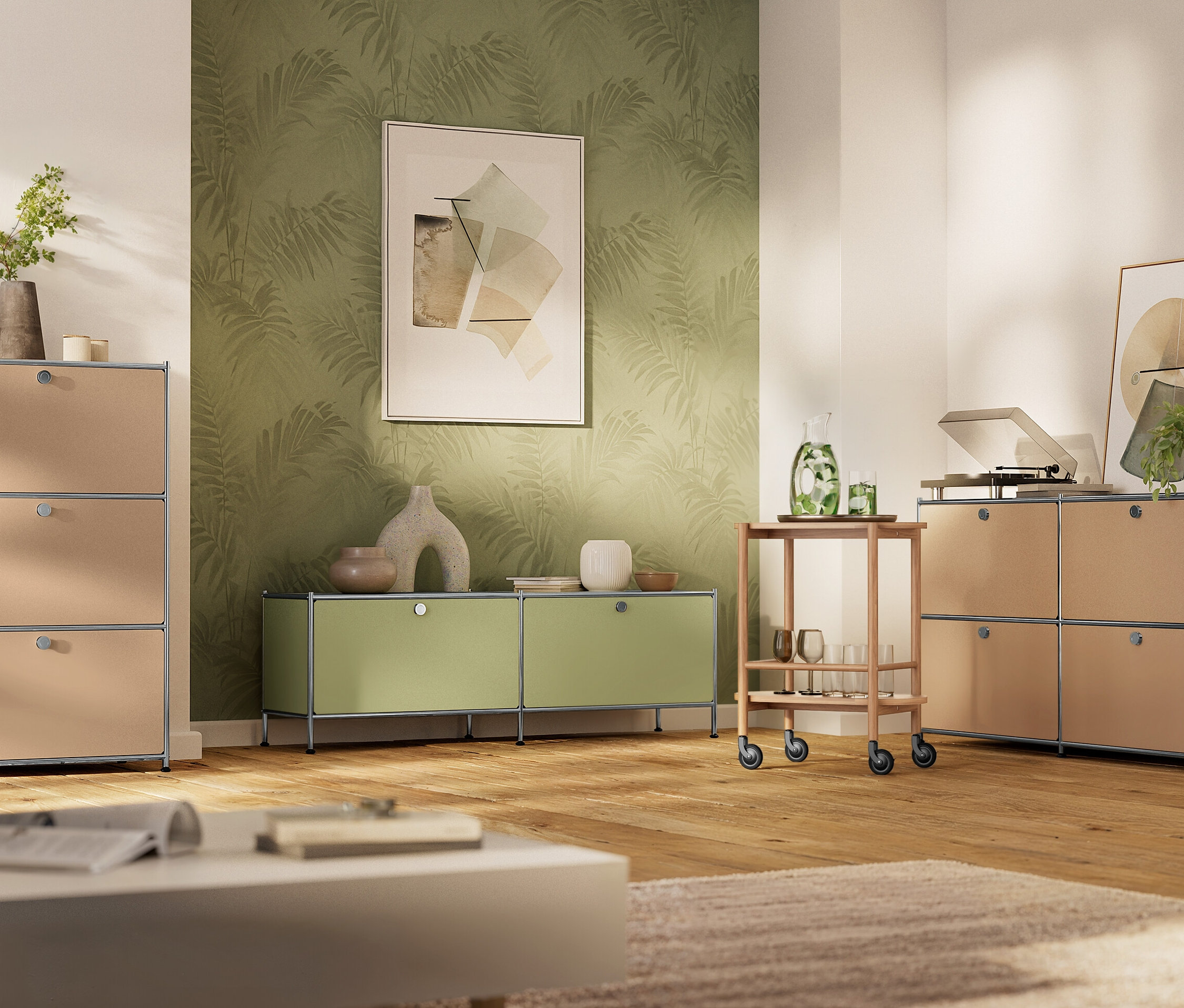 Obývacia izba s béžovým a limetkovo zeleným nábytkom USM, vrátane regálov a servírovacieho vozíka, na drevenej podlahe.