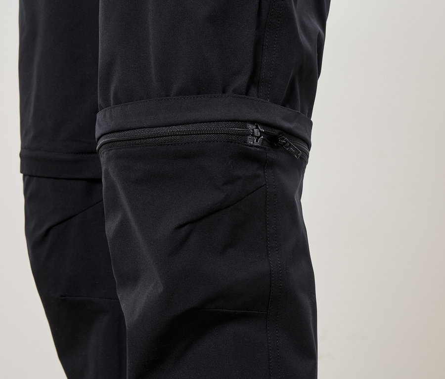 Detail spodnej časti čiernych nohavíc so zipsom na nohavici.