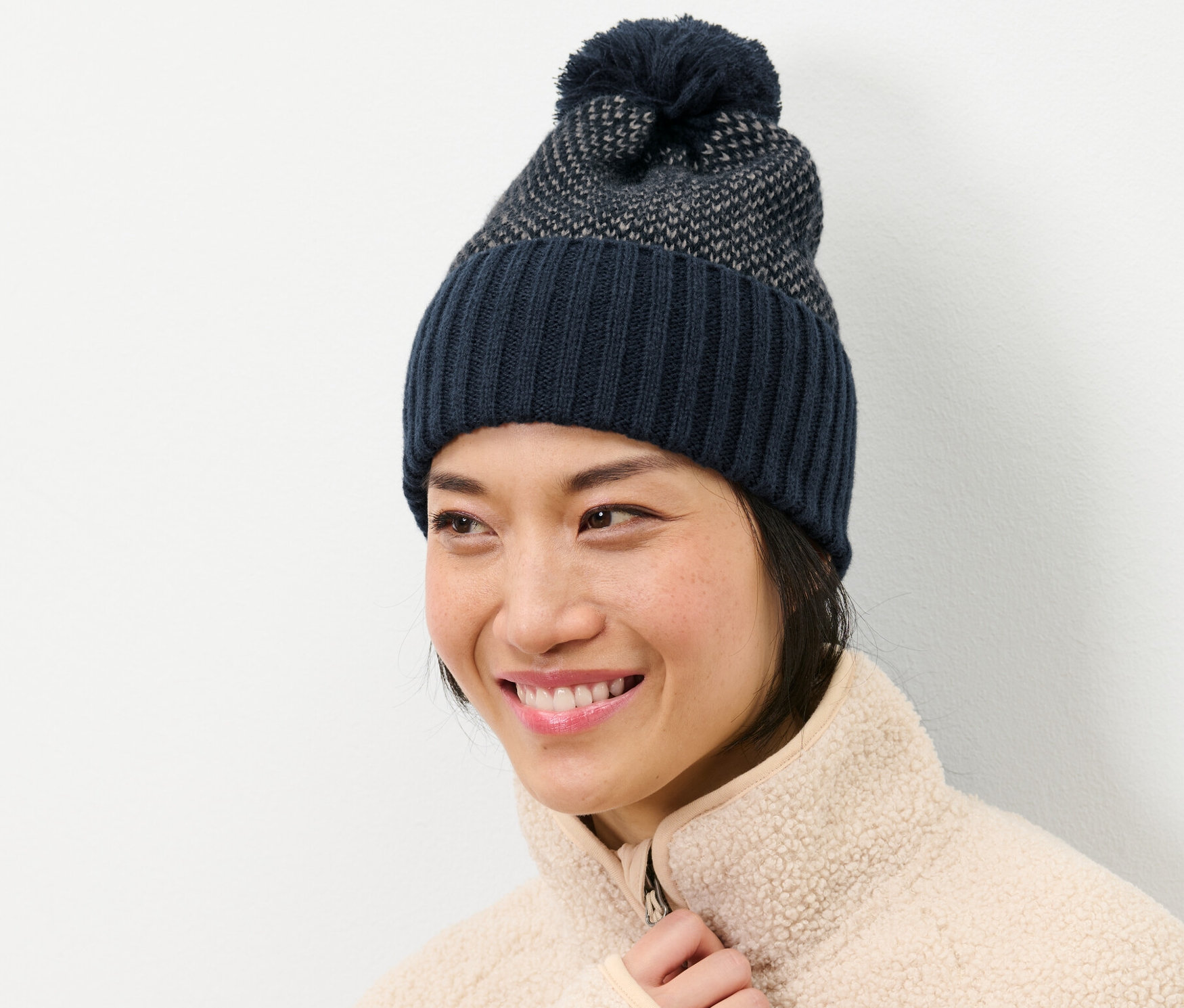 Žena sa usmieva a má na sebe pletenú čiapku.