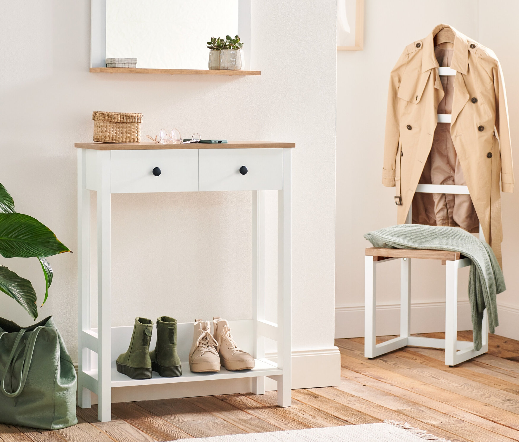 Predsieň s konzolovým stolíkom s 2 zásuvkami a nemým sluhom. Na stolíku sú kľúče a prútený košík. Pod stolíkom sú topánky a vedľa zelená taška.