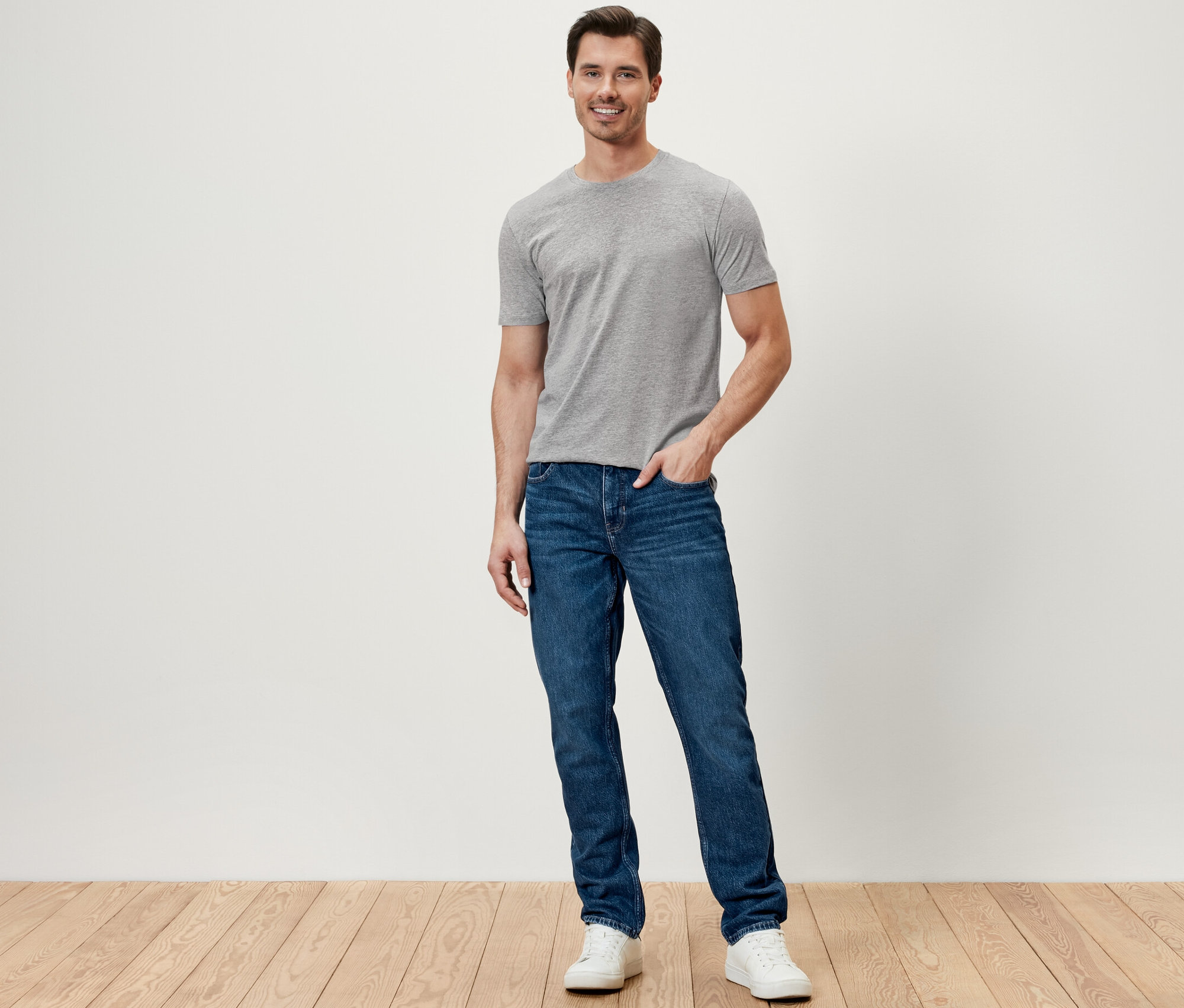 Muž stojí a má na sebe džínsy.