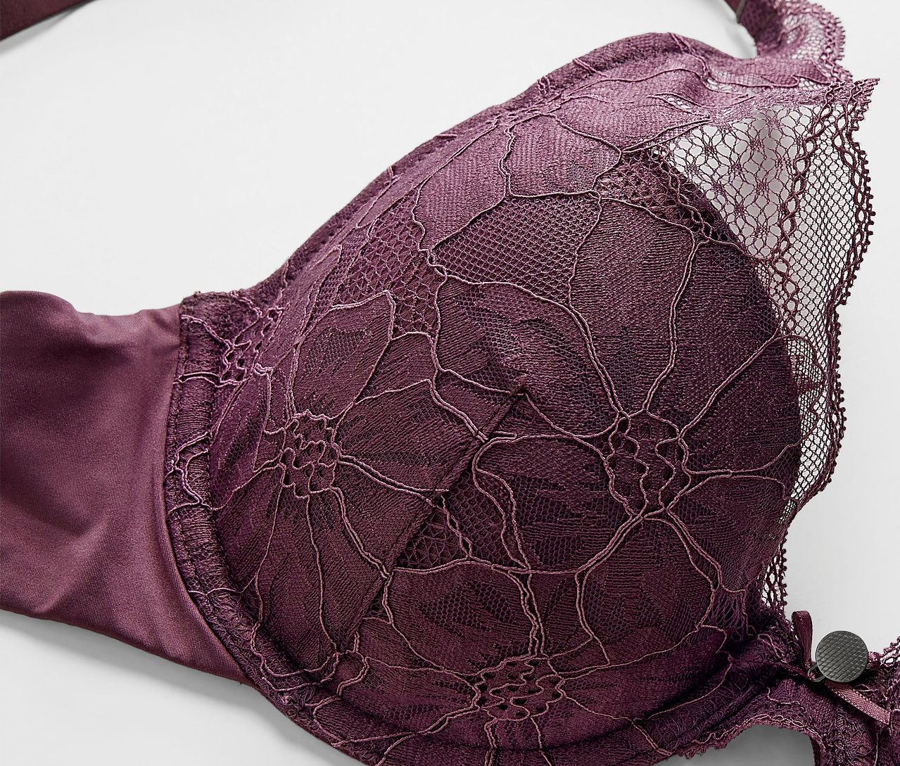 Detail fialovej podprsenky s vystuženými košíčkami s kvetinovou čipkou.