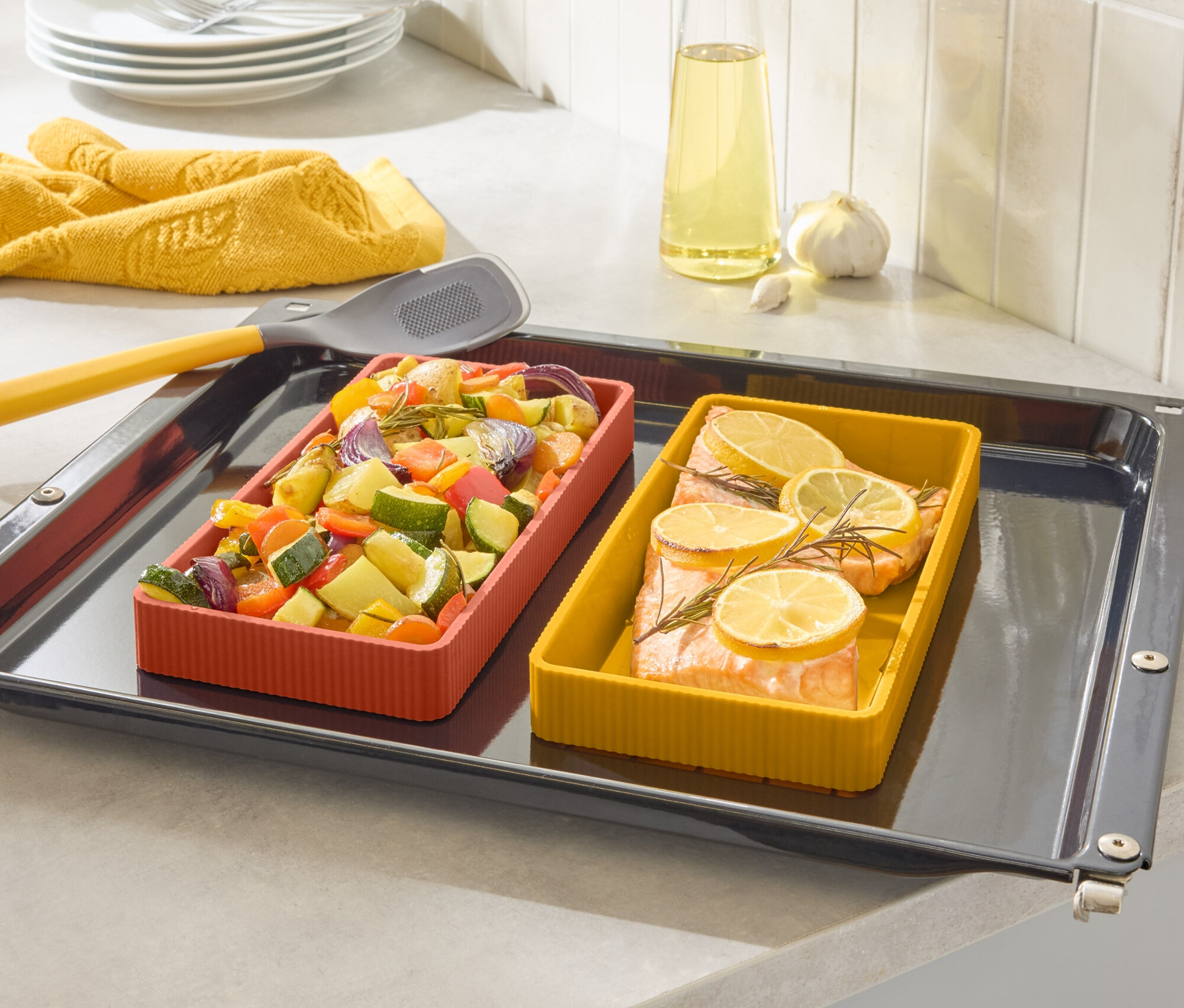 Na plechu sú dve farebné zapekacie misy, jedna s lososom a citrónom, druhá so zeleninou.