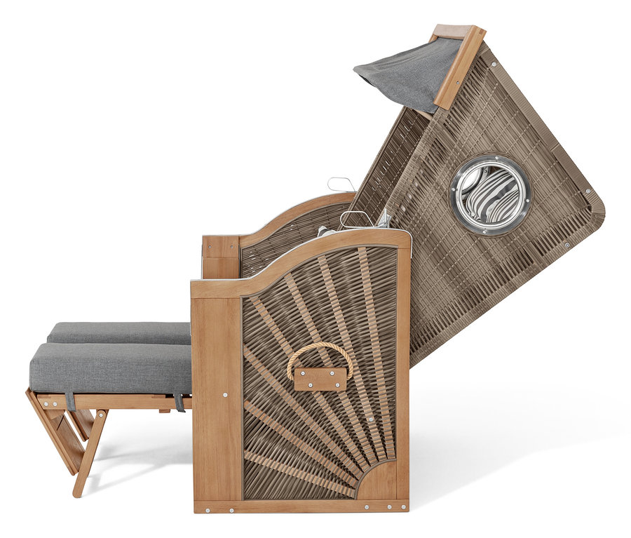 Prútený plážový kôš so sivými vankúšmi a plátennou strechou.