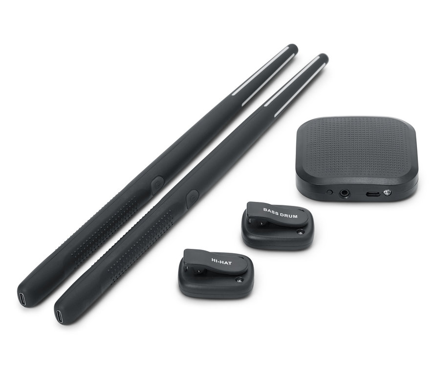Dve čierne paličky na bicie ležia vedľa seba. K dispozícii je aj čierna zvuková skrinka a dve malé čierne bicie podložky, jedna s nápisom BASS DRUM a druhá s nápisom HI-HAT.