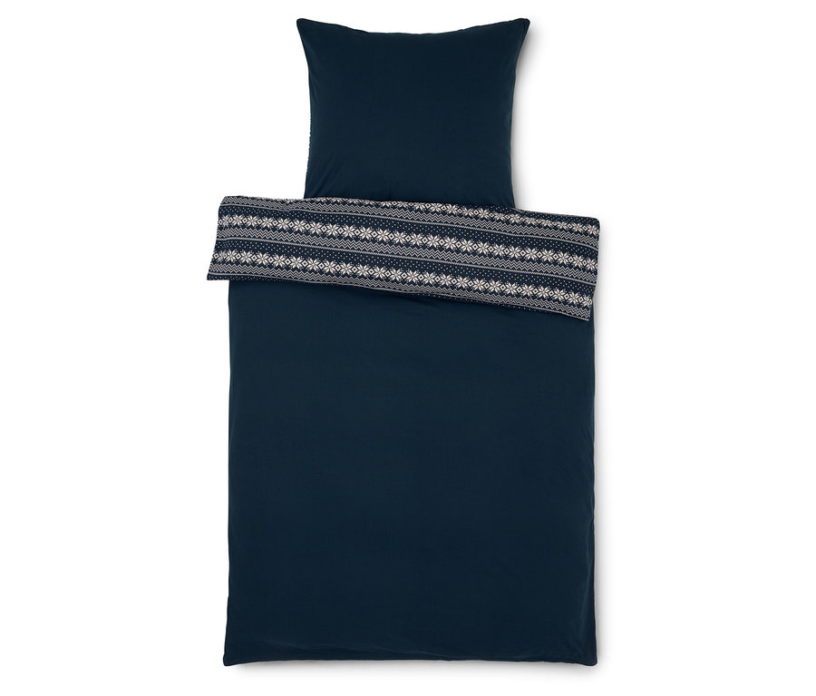 Tmavomodré obliečky s vankúšom a prehozom s bielym vzorom snehových vločiek.