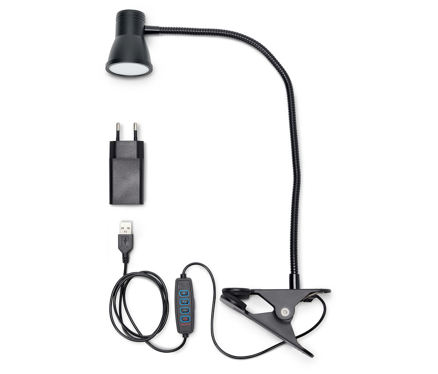 Čierna LED lampa s klipom, adaptérom a USB káblom na bielom pozadí.