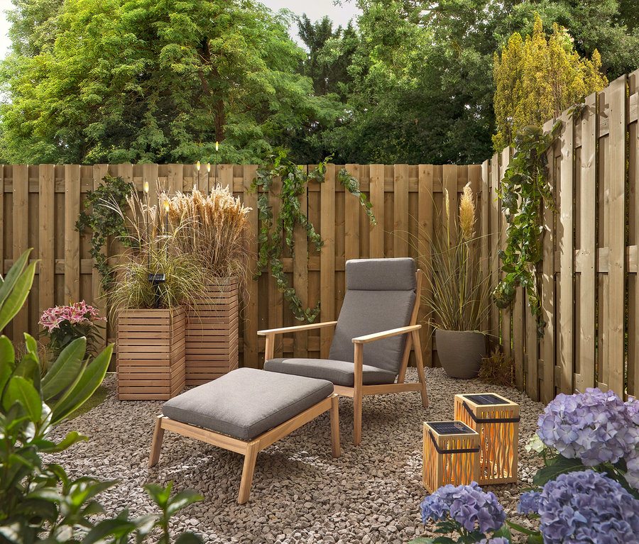 Záhrada so sivým kreslom a stoličkou, dvoma bambusovými solárnymi lampášmi a 5 LED solárnymi bodcami.